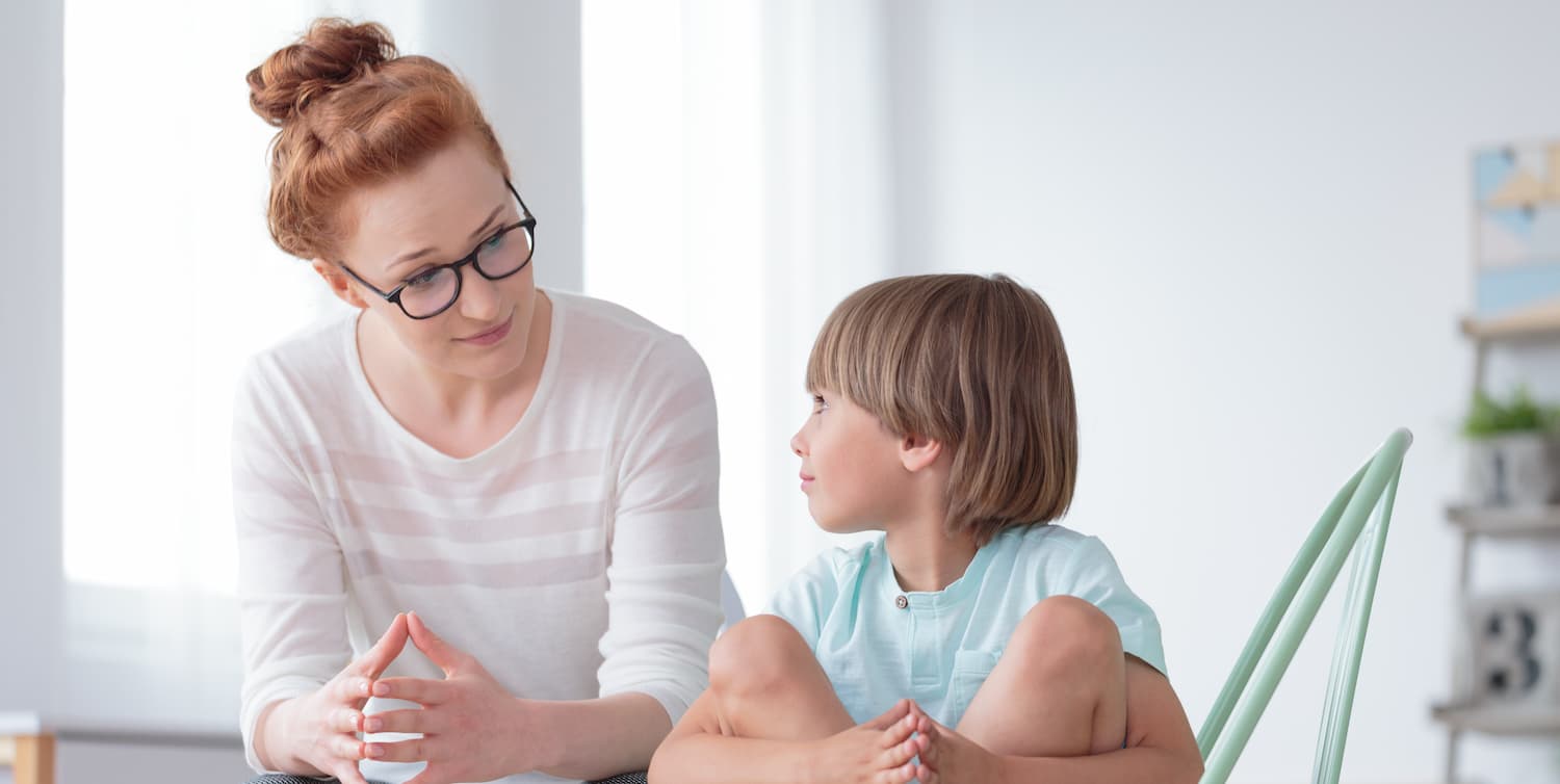 Young boy sitting beside a lady
